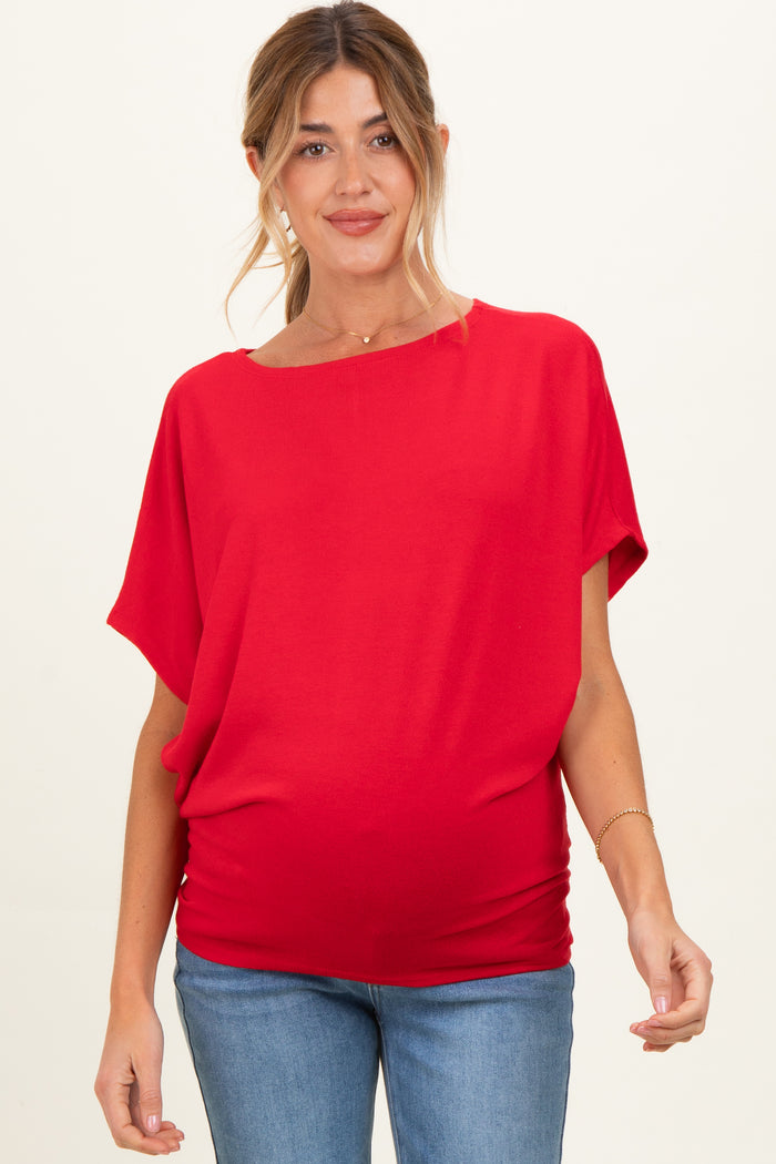 woman wearing a bright red short sleeve maternity top and showing her baby bump