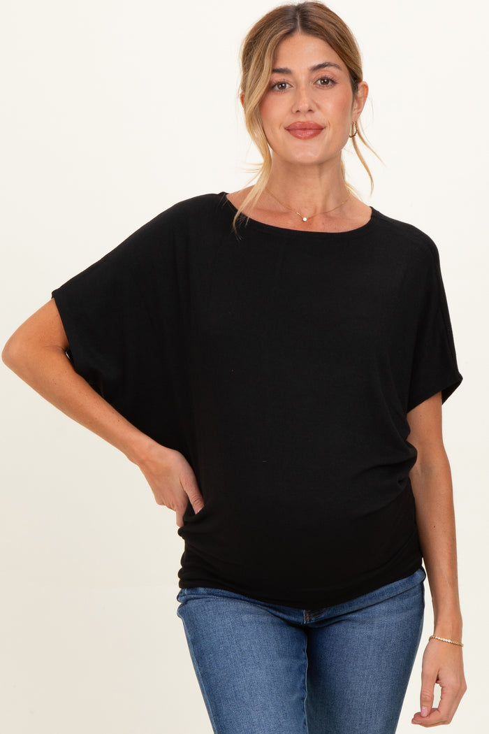 woman wearing a black maternity top with short sleeves and a relaxed fit, showing her baby bump