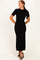 woman wearing a black ribbed knit maxi dress with short sleeves and a bow detail on the shoulder