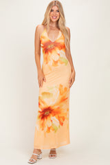 woman wearing an orange floral maxi dress with a deep V-neckline and spaghetti straps