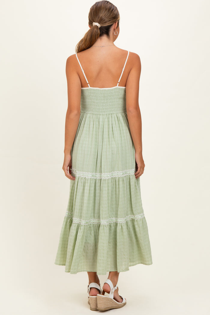 woman wearing a green tiered maternity dress with a smocked bodice and spaghetti straps, shown from the back