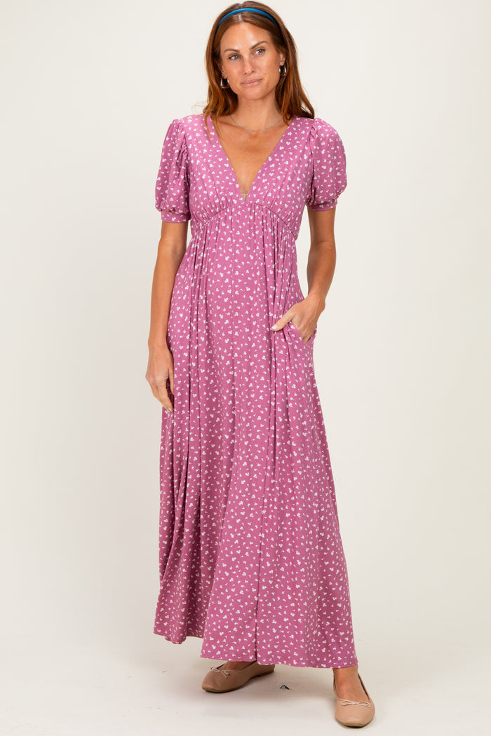 woman wearing a pink maxi dress with puff sleeves and a v-neck, featuring a white polka dot pattern and side pockets