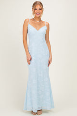 woman wearing a light blue floral evening gown with thin straps and a flared skirt