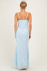 woman wearing a light blue floral maxi dress with thin straps, showing the back view