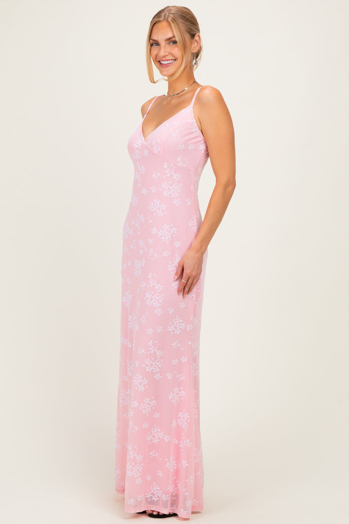 woman wearing a pink floral long dress with spaghetti straps and a fitted silhouette