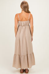 woman wearing a beige striped maxi dress with a ruffled hem and adjustable spaghetti straps