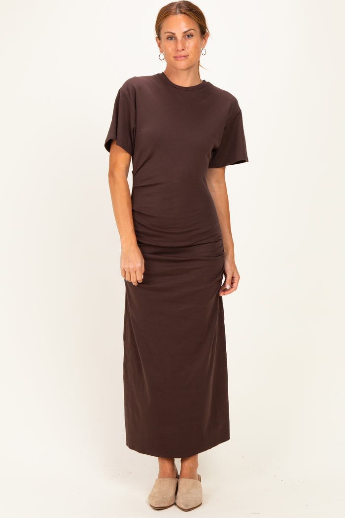 woman wearing a brown short sleeve maxi dress with a fitted silhouette and side ruching