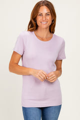 woman wearing a light purple short sleeve t-shirt and smiling at the camera