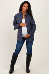 woman wearing a navy checkered maternity shirt and denim jeans, holding her baby bump