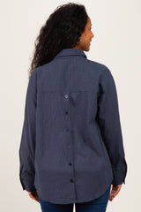woman wearing a navy blue checked maternity shirt with a button-up back and long sleeves