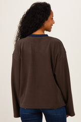 woman wearing a brown striped maternity sweatshirt with a navy neckline, showing a relaxed fit and long sleeves