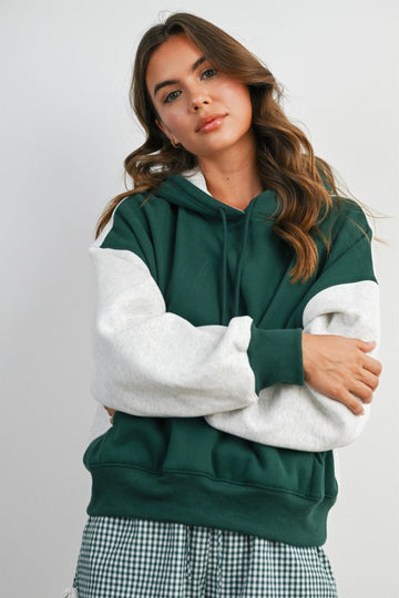 woman wearing a green and gray colorblock hoodie with a relaxed fit and drawstring hood