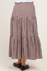 woman wearing a brown and white gingham maternity maxi skirt with tiered ruffles