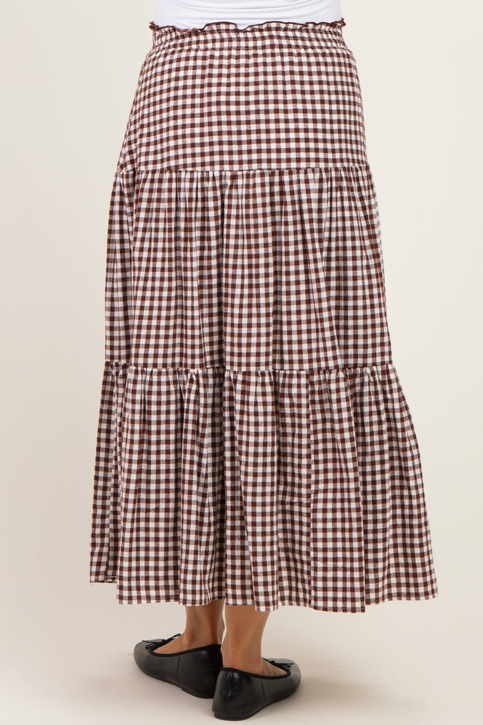woman wearing a brown and white gingham maternity maxi skirt with tiered ruffles