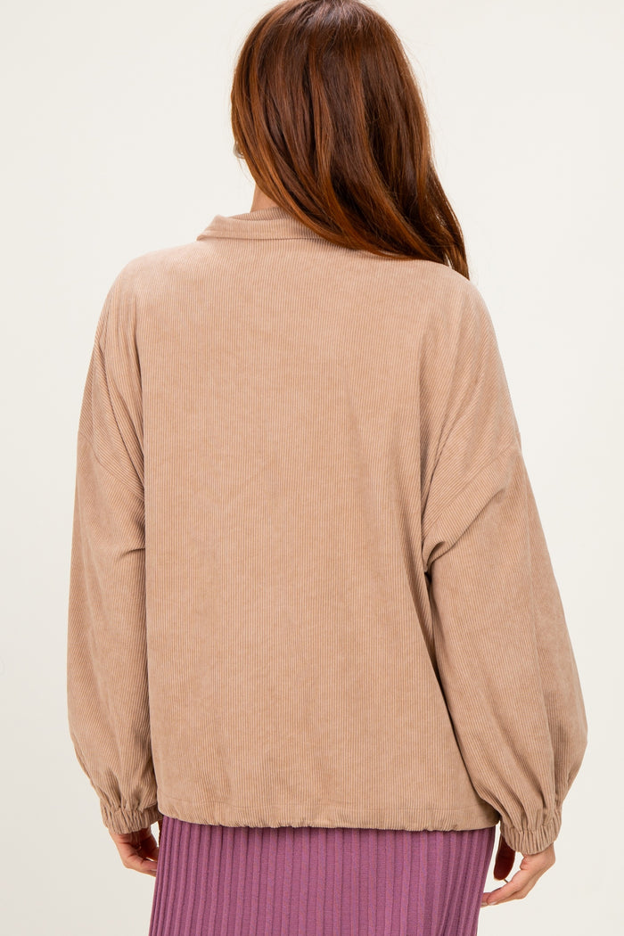 woman wearing a tan corduroy oversized jacket with balloon sleeves, viewed from the back