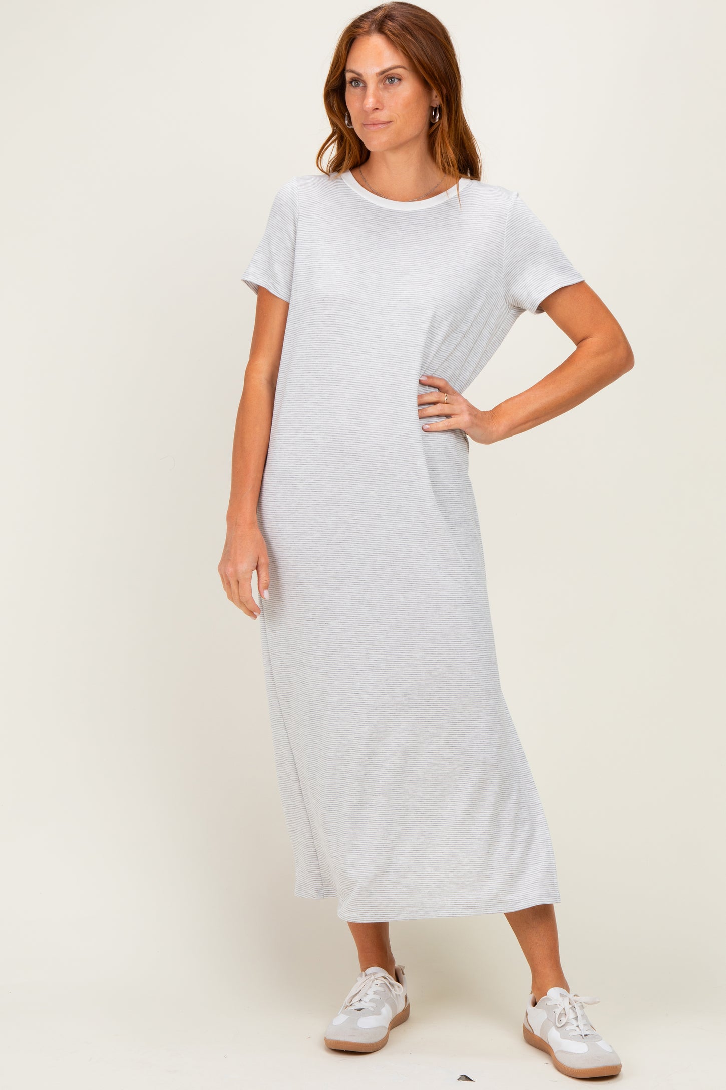woman wearing a light grey short sleeve maxi dress styled with casual white sneakers