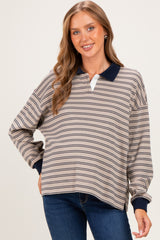 woman wearing a striped beige and navy maternity top with a collared neckline and relaxed fit
