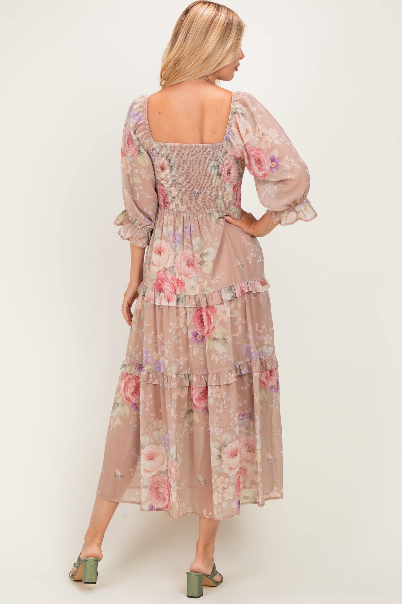 woman wearing a floral maxi dress with a square neckline and tiered ruffle detail, showing a smocked back and puff sleeves