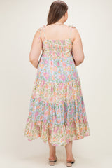 woman wearing a floral print maternity plus maxi dress with adjustable tie straps and tiered ruffles, shown from the back
