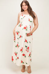 woman wearing a floral print white maternity maxi dress and holding her baby bump