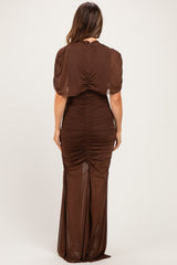 woman wearing a brown ruched maternity dress with a fitted silhouette and short sleeves, showing her baby bump from the back