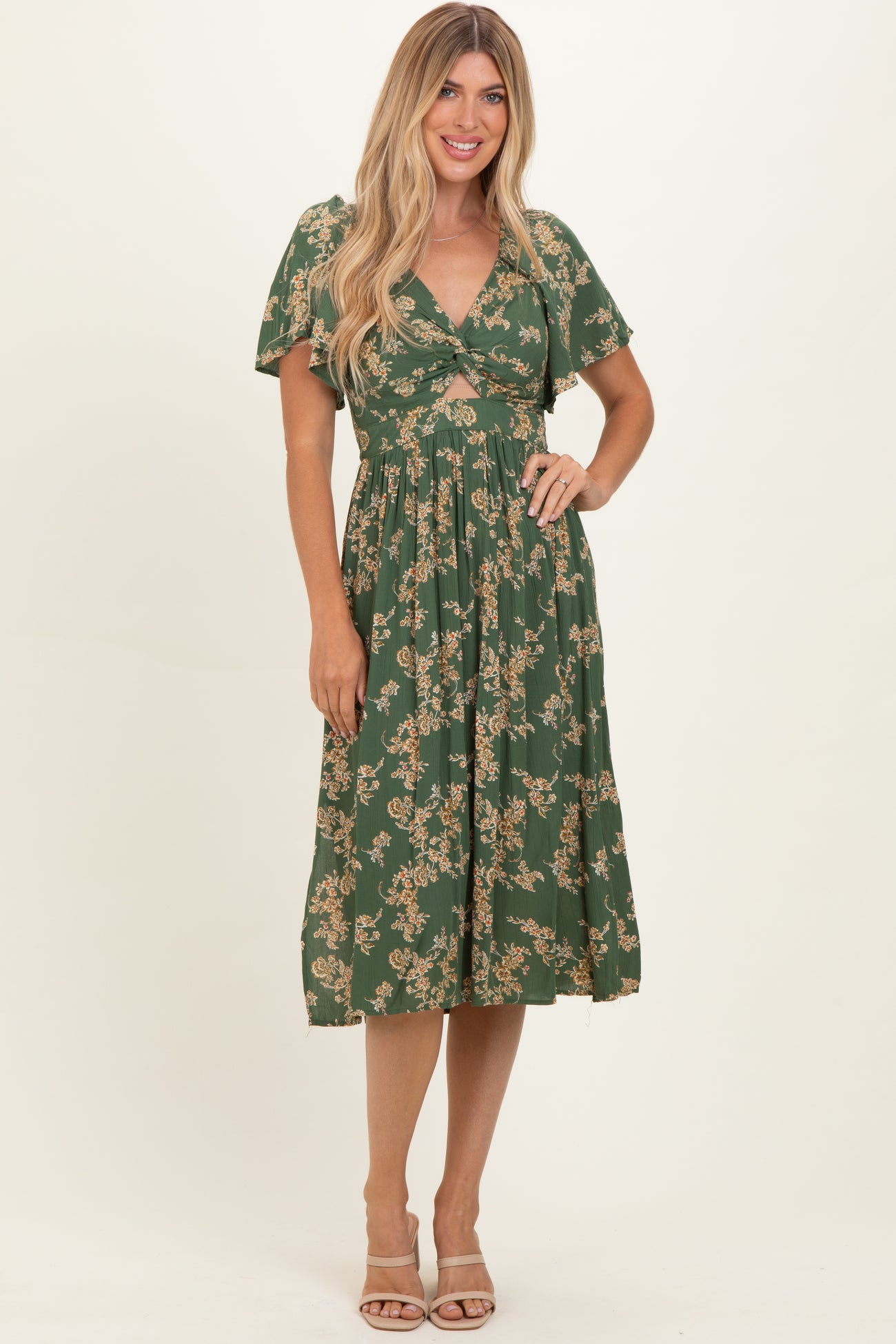 woman wearing a green floral midi dress with short sleeves and a twist front detail