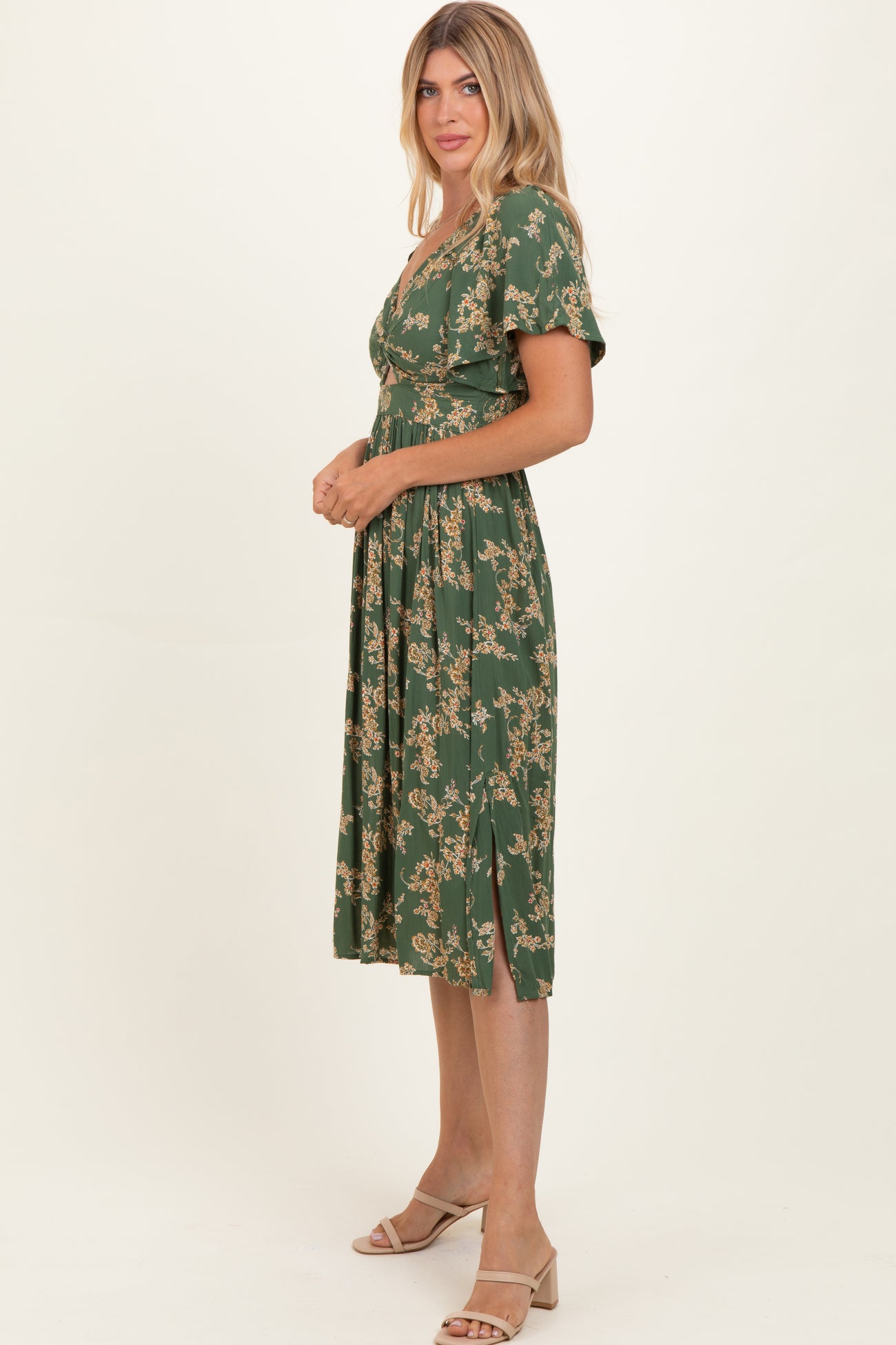 woman wearing a green floral midi dress with a v-neckline and short sleeves
