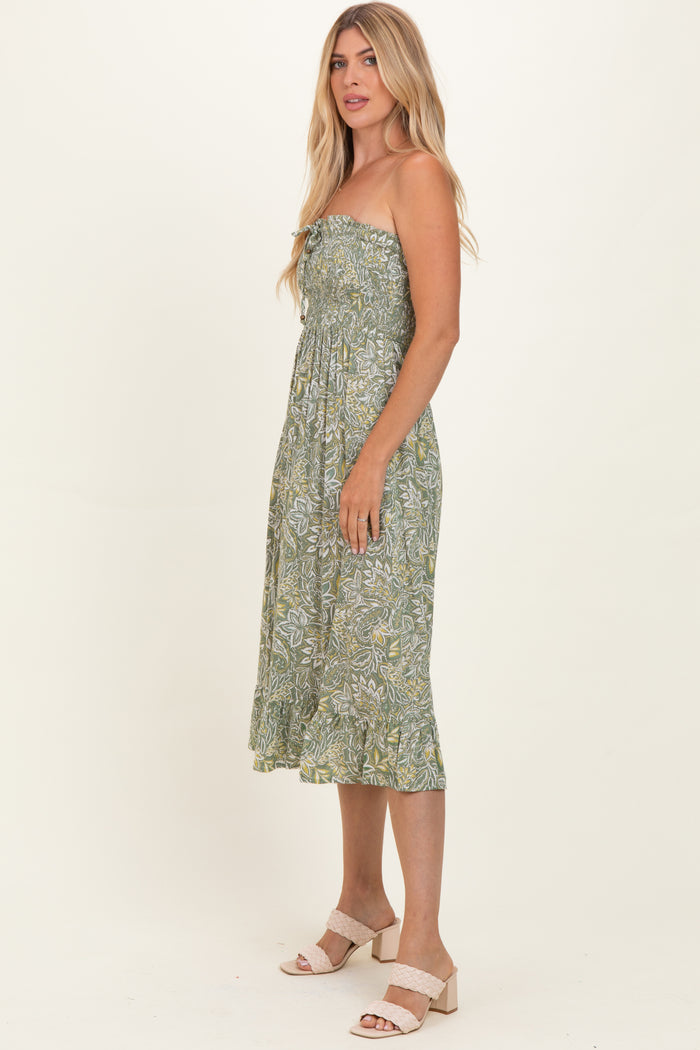 woman wearing a green strapless floral midi dress with a fitted bodice and flared hem, standing sideways