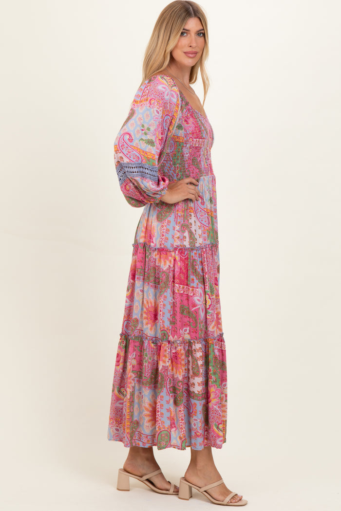 woman wearing a colorful bohemian maxi dress with puff sleeves and tiered ruffles
