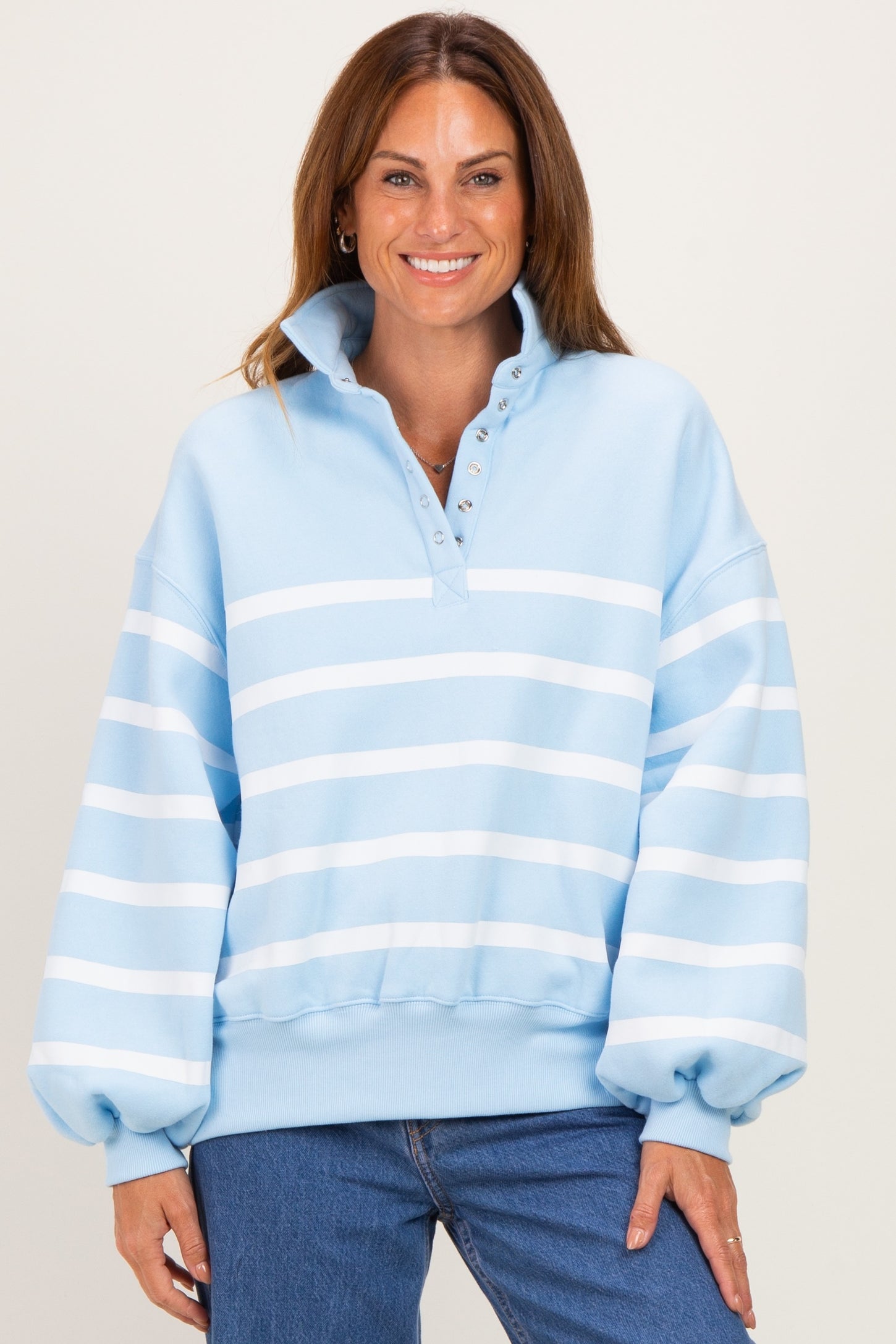 woman wearing a light blue striped pullover sweatshirt with a collar and long sleeves