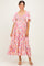woman wearing a pink floral maternity maxi dress with short flutter sleeves and a smocked bodice
