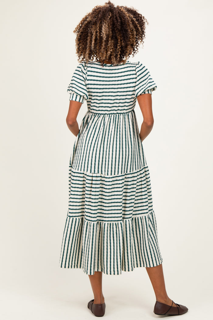 woman wearing a green and white striped maternity maxi dress with short sleeves and tiered ruffles