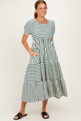 woman wearing a striped tiered midi dress with puff sleeves and pockets, standing and smiling