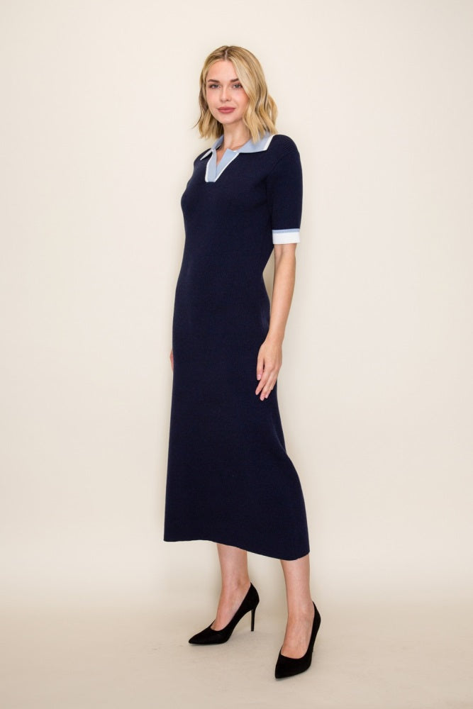 woman wearing a navy blue knitted midi dress with a light blue collar and short white sleeves, paired with black heels