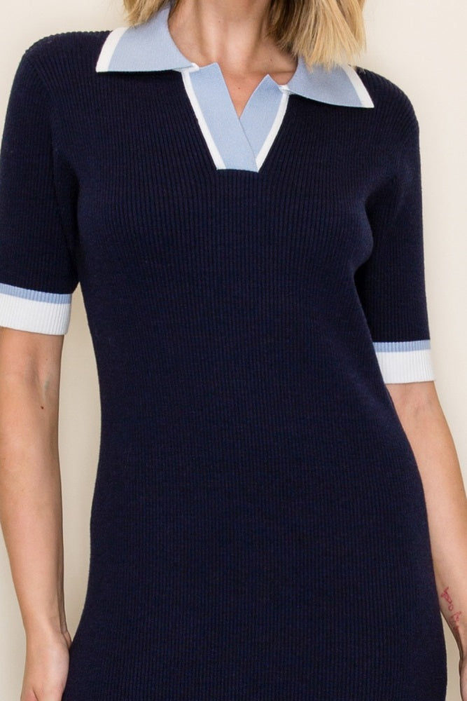 woman wearing a navy blue ribbed polo dress with light blue collar and sleeves