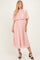 woman wearing a blush pink pleated midi dress with flutter sleeves and a flowy silhouette