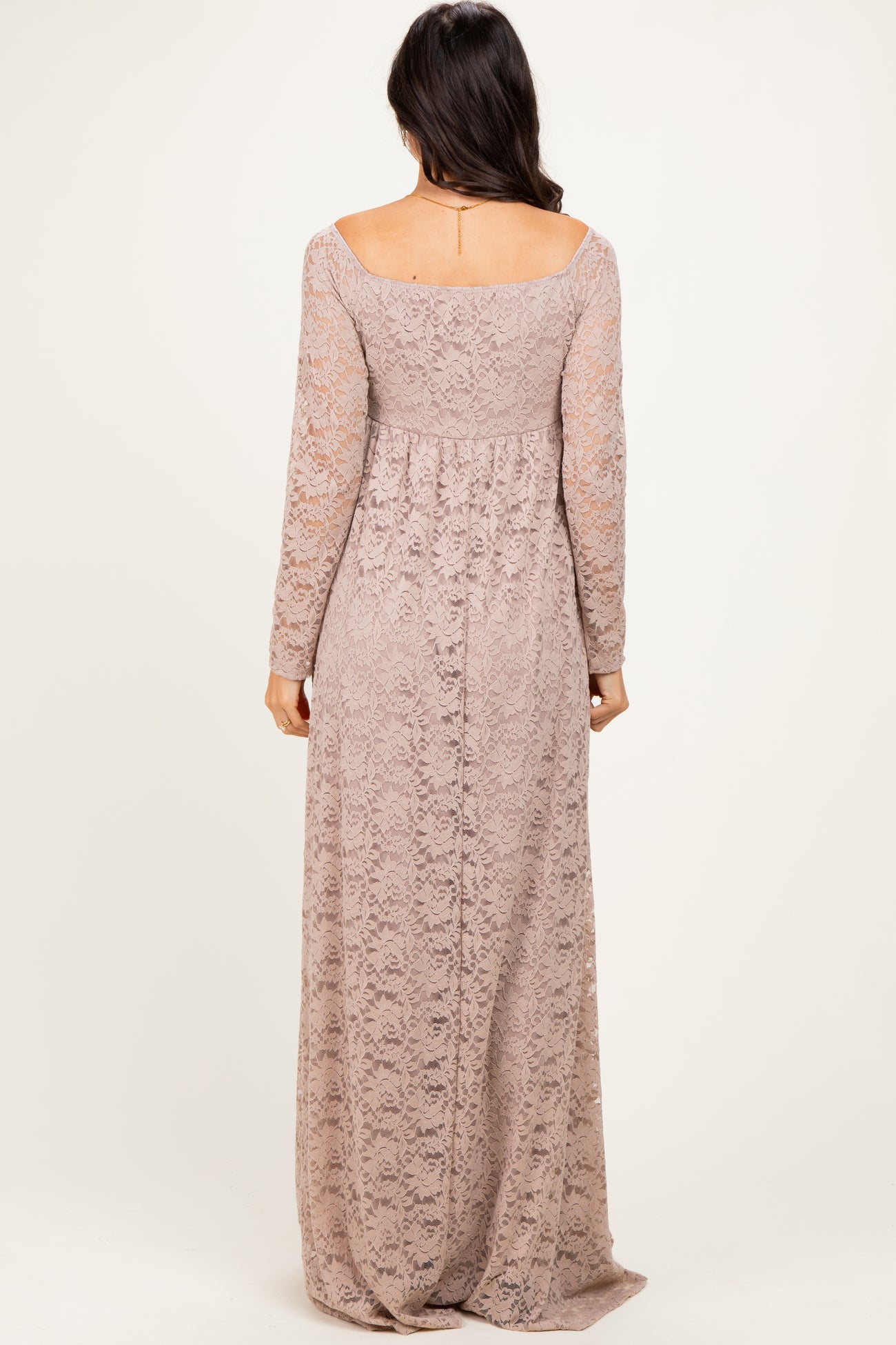 woman wearing a long lace mauve dress with long sleeves and a fitted bodice, shown from the back