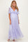 woman wearing a lavender lace maternity maxi dress with a tie front and flutter sleeves, showing her baby bump