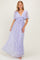 woman wearing a lavender lace maxi dress with short flutter sleeves and a tied front detail