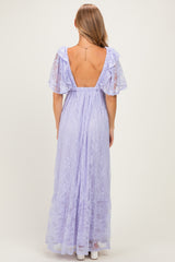 woman wearing a lavender long maxi dress with lace details and ruffled sleeves, showing an open back