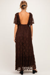 woman wearing a brown lace maternity maxi dress with short puff sleeves and a low back