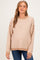woman wearing a tan and cream striped maternity sweater with a relaxed fit and a rounded neckline