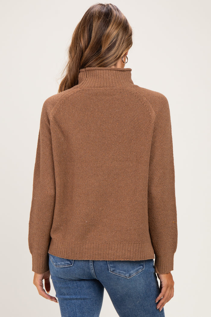 woman wearing a brown maternity sweater with a high neck and long sleeves, shown from the back