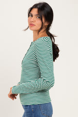 woman wearing a green and white striped long sleeve henley top with buttons and a fitted style
