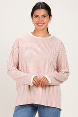woman wearing a pink and white striped long sleeve top with a relaxed fit and a round neckline