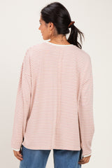 woman wearing a pink and white striped long sleeve top, view from the back with relaxed fit and dropped shoulders