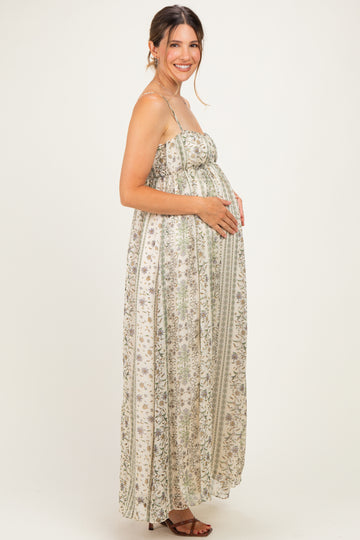 woman wearing a floral printed maternity maxi dress and gently holding her baby bump