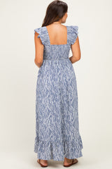 woman wearing a blue and white patterned maternity maxi dress with ruffled straps and a tiered hem