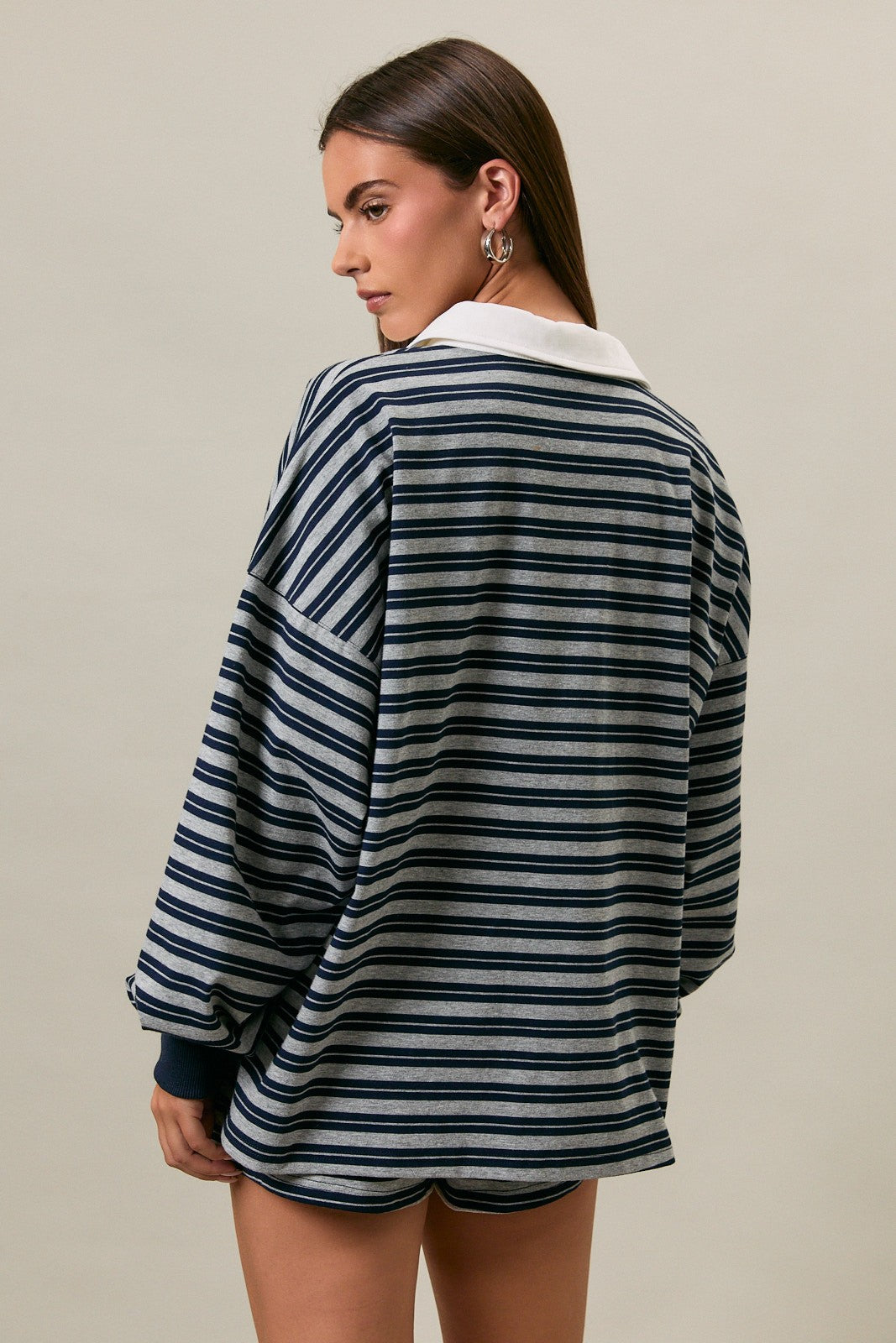 woman wearing a navy and gray striped oversized sweatshirt with a white collar and long sleeves