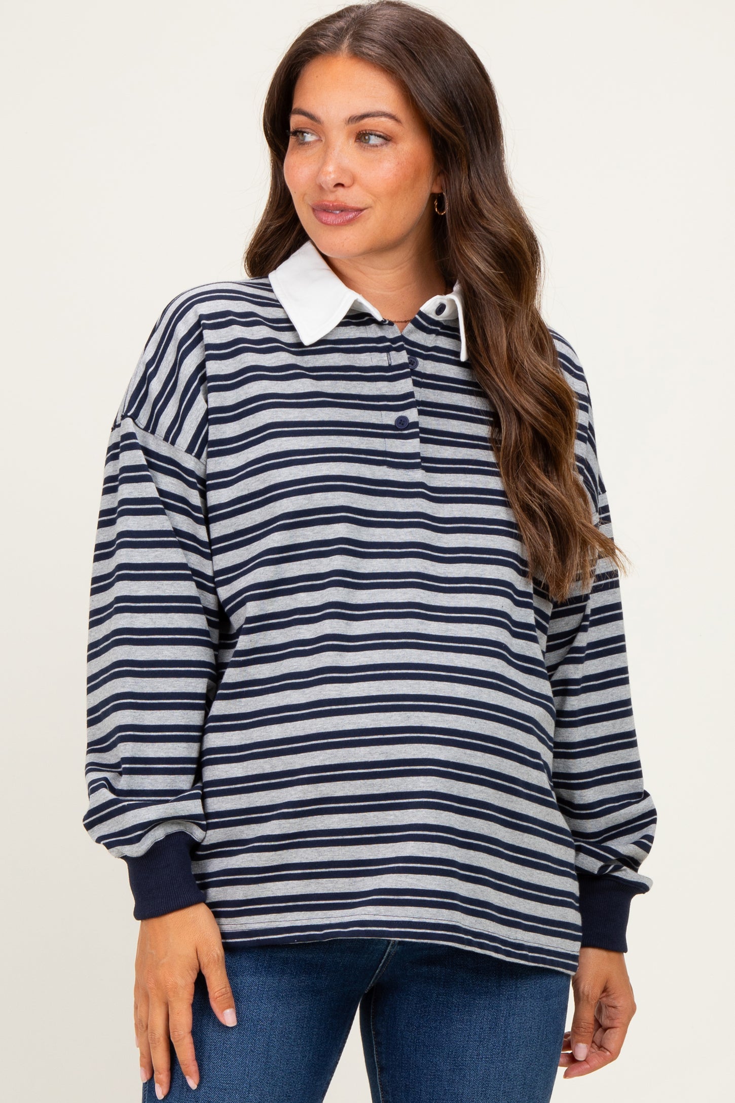 woman wearing a navy and gray striped maternity pullover with a white collar and relaxed fit showing her baby bump
